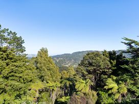 A scenic outdoor view of trees and hills at Roberts Retreat - Auckland Holiday Home in Laingholm
