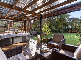 An outdoor patio with furniture and a grill at Roberts Retreat - Auckland Holiday Home Laingholm