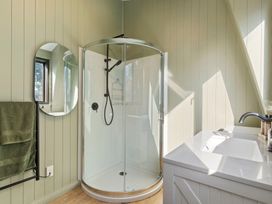 A bathroom with a shower and sink at Roberts Retreat - Auckland Holiday Home Laingholm
