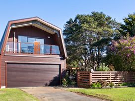 An exterior view of a house with a garage and balcony at Roberts Retreat - Auckland Holiday Home in Laingholm