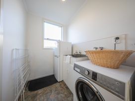 A laundry room with a washing machine and a sink at The Green House