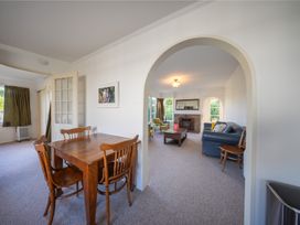 A dining area with a table and chairs near a living room at The Green House 