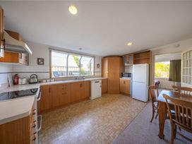 A kitchen with appliances and a dining table at The Green House