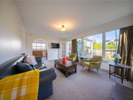 A living room with a sofa, coffee table, and armchairs at The Green House 