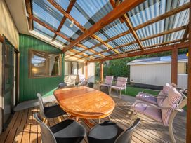 An outdoor patio with a wooden table and chairs at The Green House 
