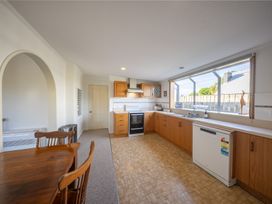 A kitchen with a stove and a dining table at The Green House 
