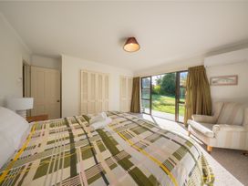 A bedroom with a bed and a view of the garden at The Green House