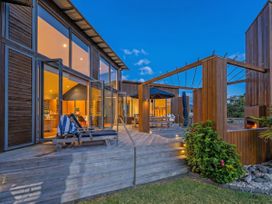 An outdoor area with wooden deck and sun loungers at Ocean Breeze Family Haven - Pauanui