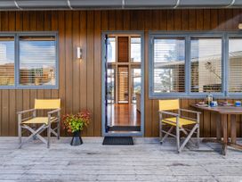 An outdoor area with two chairs and a table at Ocean Breeze Family Haven - Pauanui
