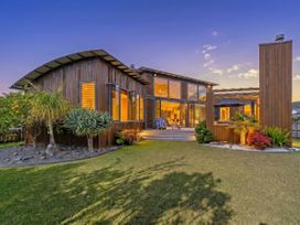 A house with large windows and patio area at Ocean Breeze Family Haven - Pauanui