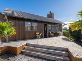 A house with a wooden deck and steps at Ocean Breeze Family Haven - Pauanui
