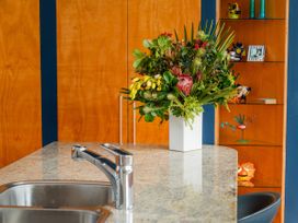 A kitchen with a sink and a flower arrangement at Ocean Breeze Family Haven - Pauanui