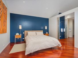 A bedroom with a bed and lamp at Ocean Breeze Family Haven - Pauanui Holiday Home Pauanui