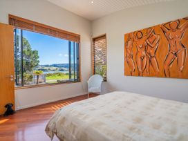 A bedroom with a bed and window view at Ocean Breeze Family Haven - Pauanui