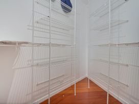 A pantry with wire shelves at Ocean Breeze Family Haven - Pauanui