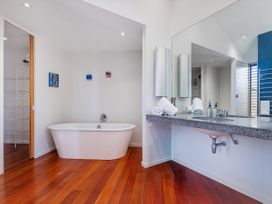 A bathroom with a bathtub and sink at Ocean Breeze Family Haven - Pauanui