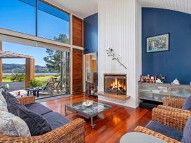 A living room with a fireplace and a coffee table at Ocean Breeze Family Haven - Pauanui