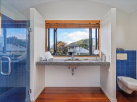 A bathroom with a shower, sink, and toilet at Ocean Breeze Family Haven - Pauanui
