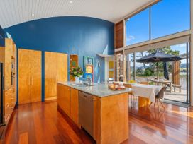 A kitchen with an island and dining area at Ocean Breeze Family Haven - Pauanui