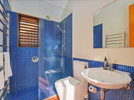 A bathroom with a shower and sink at Ocean Breeze Family Haven - Pauanui