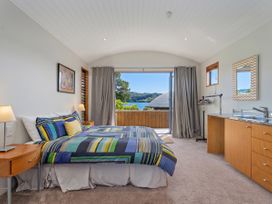 A bedroom with a bed and dresser at Ocean Breeze Family Haven - Pauanui