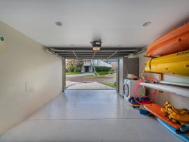 A garage with kayaks and a washing machine at Ocean Breeze Family Haven - Pauanui