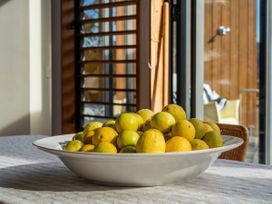 A bowl of lemons on a table in a kitchen at Ocean Breeze Family Haven - Pauanui