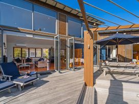 An outdoor area with dining table and sun loungers at Ocean Breeze Family Haven - Pauanui