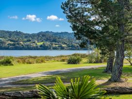 A view of a water body with trees and grass at Ocean Breeze Family Haven - Pauanui