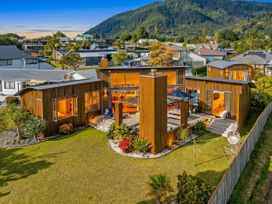 An outdoor view of a house with garden and deck at Ocean Breeze Family Haven - Pauanui