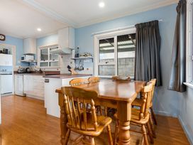 A kitchen with a dining table and chairs at Tauranga Holiday Home in Tauranga