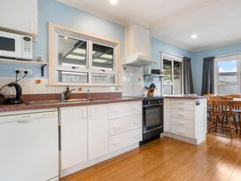 A kitchen with appliances and dining area at Tauranga Holiday Home in Tauranga