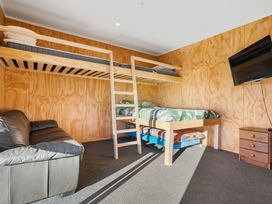 A bedroom with a bunk bed and a double bed at Panorama View Retreat - Bachcare Holiday Home Pauanui