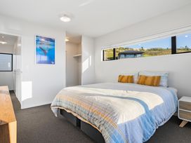A bedroom with a bed and window at Panorama View Retreat - Bachcare Holiday Home Pauanui