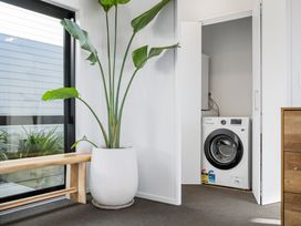 A laundry room with a washer and plant at Panorama View Retreat - Bachcare Holiday Home Pauanui