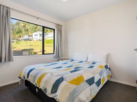 A bedroom with a bed and window at Panorama View Retreat - Bachcare Holiday Home Pauanui