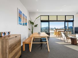 A living room with a dining table and sliding doors at Panorama View Retreat - Pauanui