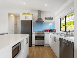 A kitchen with a refrigerator, stove, and sink at Panorama View Retreat - Pauanui