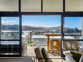 A living room with a view of the water and hills at Panorama View Retreat - Bachcare Holiday Home in Pauanui