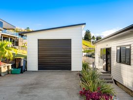 A garage beside a house with a pathway at Panorama View Retreat - Bachcare Holiday Home, Pauanui