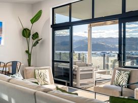 A living room with a sofa and chairs at Panorama View Retreat - Bachcare Holiday Home Pauanui