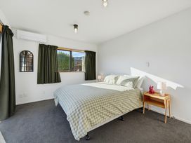 A bedroom with a bed and curtains at Belle Vue in Akaroa
