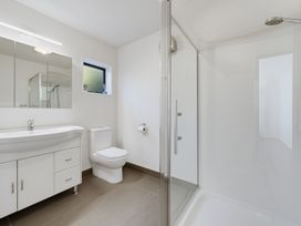 A bathroom with a sink, toilet, shower, and mirror at Belle Vue in Akaroa