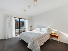 A bedroom with a bed and curtains at Belle Vue in Akaroa