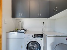 A laundry room with a washing machine and sink at Belle Vue in Akaroa