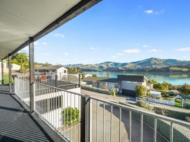 A balcony overlooking houses and water at Belle Vue in Akaroa
