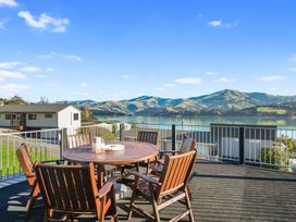 An outdoor seating area with table and chairs overlooking a lake at Belle Vue Akaroa