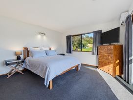 A bedroom with a bed and television at Belle Vue in Akaroa