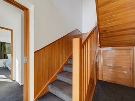 A hallway with a staircase and door at Belle Vue in Akaroa