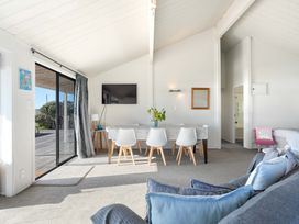 A dining room with a table and chairs at Sandbanks, Papamoa Holiday Home in Papamoa